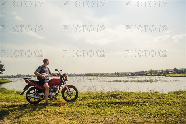 Caucasian man sitting on motorcycle in park