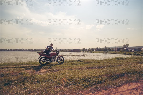 Caucasian man sitting on motorcycle in park