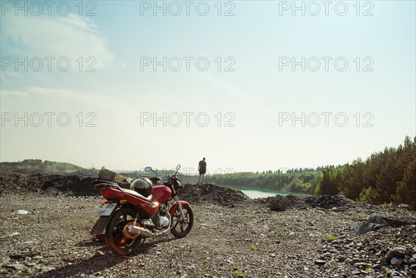 Caucasian man and motorcycle in rural field