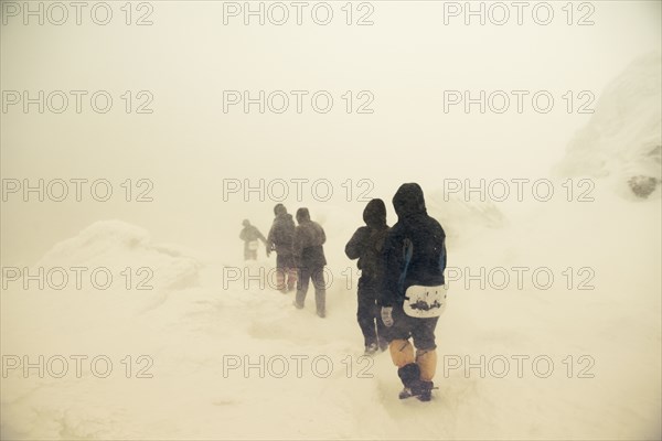 Caucasian hikers walking on snowy path