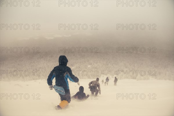 Caucasian hikers walking on snowy hill