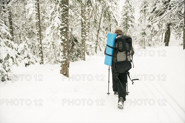 Caucasian hiker walking in snowy forest