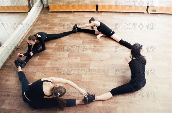 Caucasian dancers stretching in studio