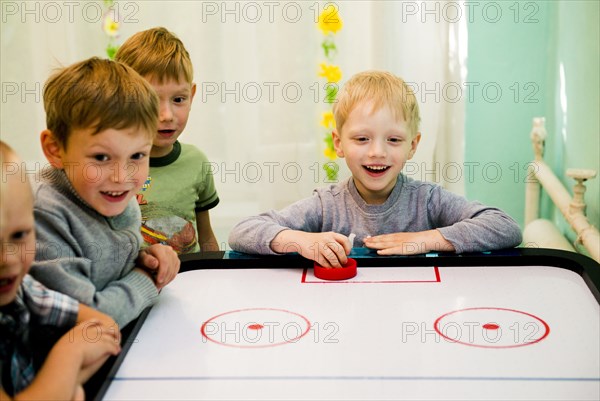 Caucasian boys playing air hockey