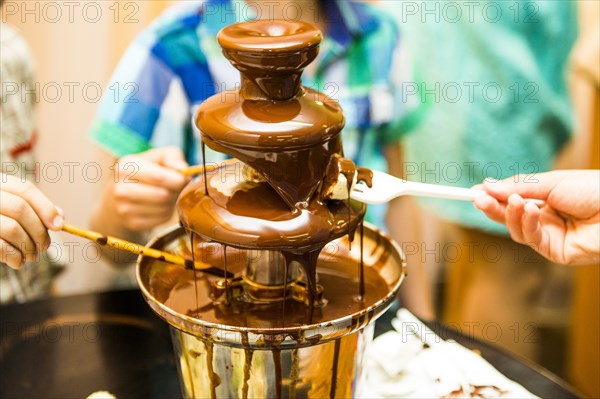 People eating from chocolate fountain