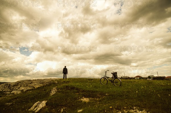 Caucasian man with bicycle in field