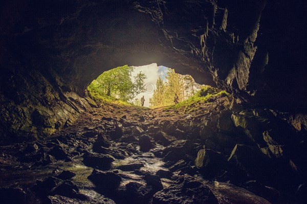 Hikers standing at entrance of cave