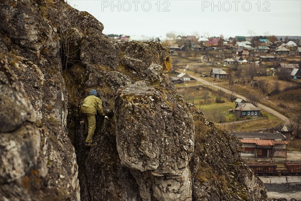 Hiker climbing rocky mountainside