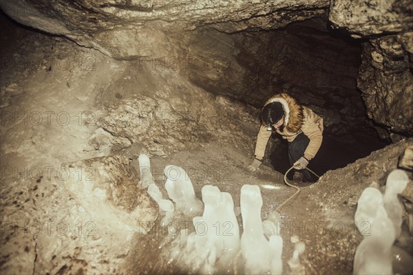 Caucasian hiker climbing in cave