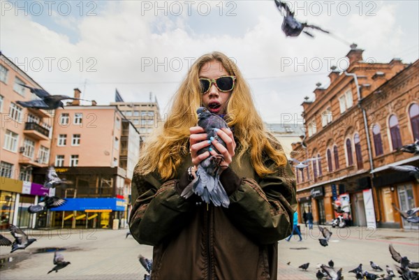 Caucasian woman holding pigeon