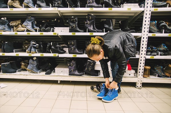 Caucasian woman trying on shoes in store