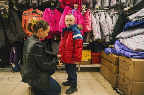 Caucasian mother and son shopping in store