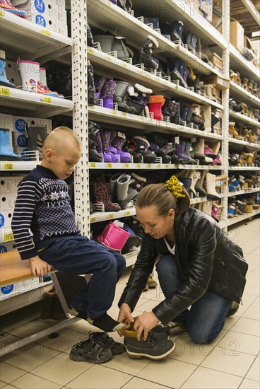 Caucasian mother and son shopping in store