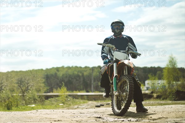 Caucasian man riding dirt bike in field