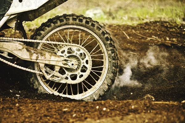 Dirt bike tire smoking in dirt