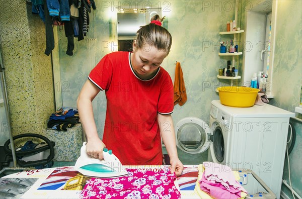 Caucasian woman ironing laundry