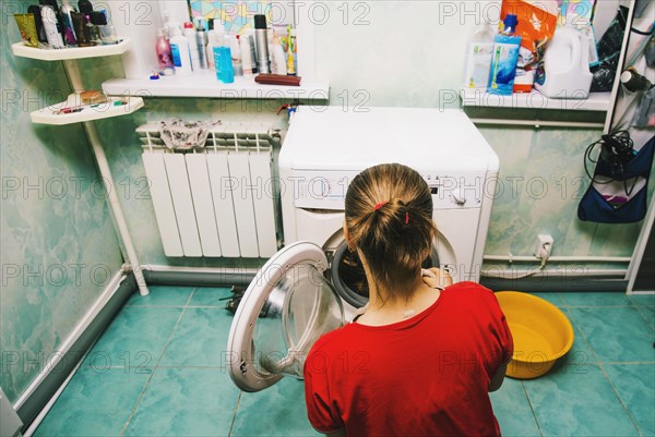 Caucasian woman loading laundry in dryer