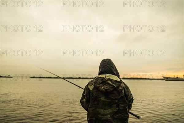Caucasian man fishing in remote lake
