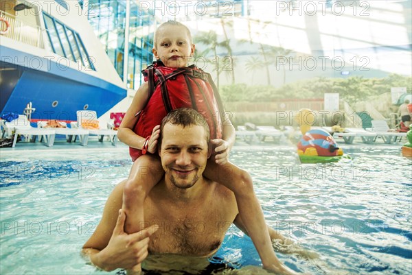 Caucasian father and son swimming in pool