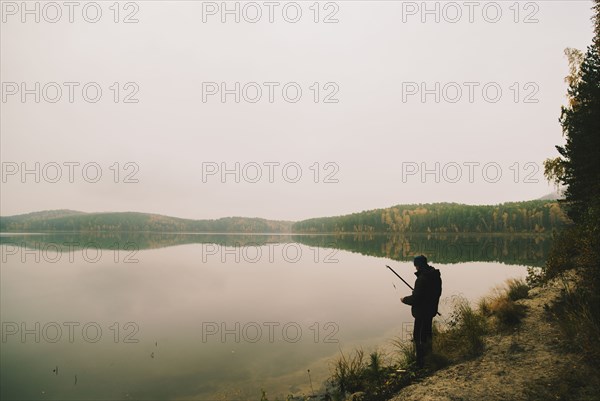 Man fishing in remote lake