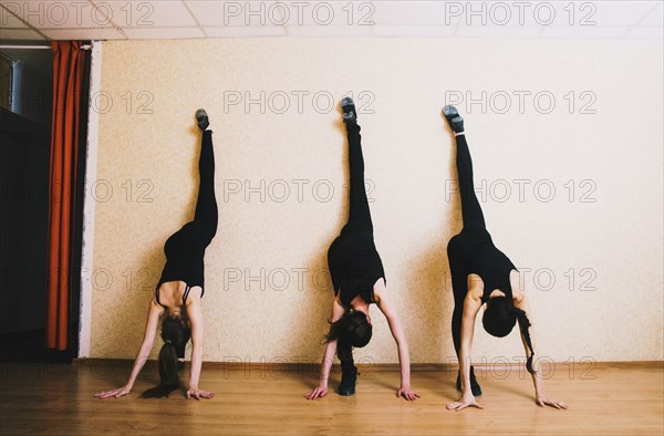 Caucasian dancers stretching in studio