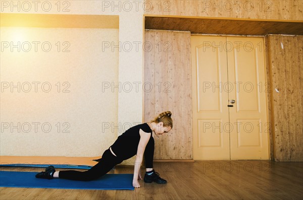 Caucasian dancer stretching in studio