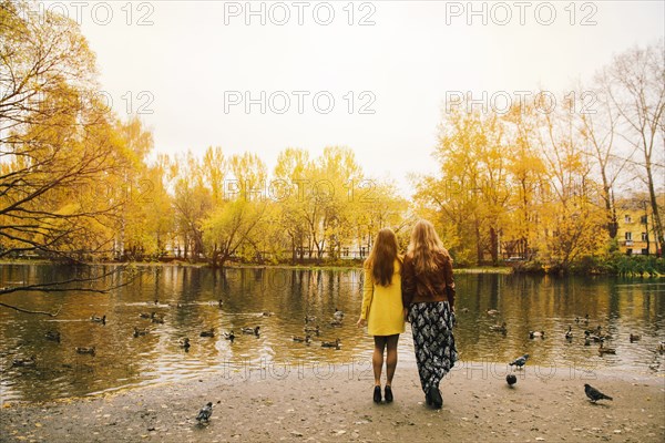 Caucasian women admiring pond in park