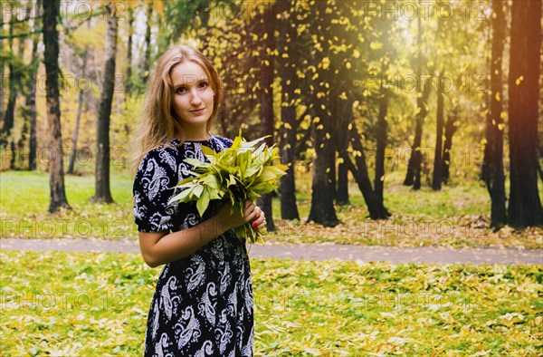 Caucasian woman carrying bouquet in park