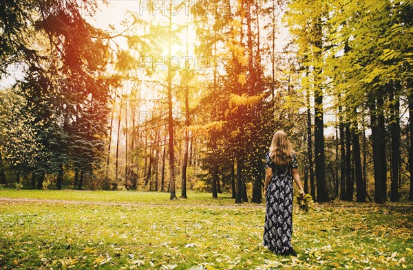 Caucasian woman carrying bouquet in park