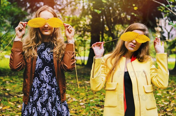 Caucasian women playing with autumn leaves