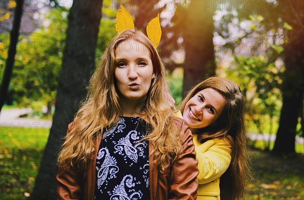 Caucasian women playing with autumn leaves