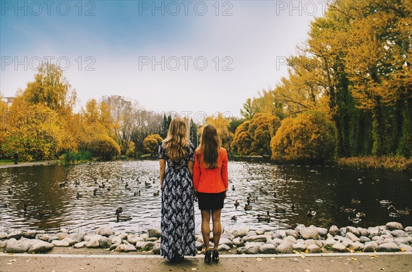 Caucasian women admiring pond in park