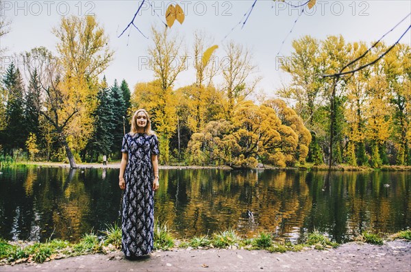 Caucasian woman smiling near pond in park