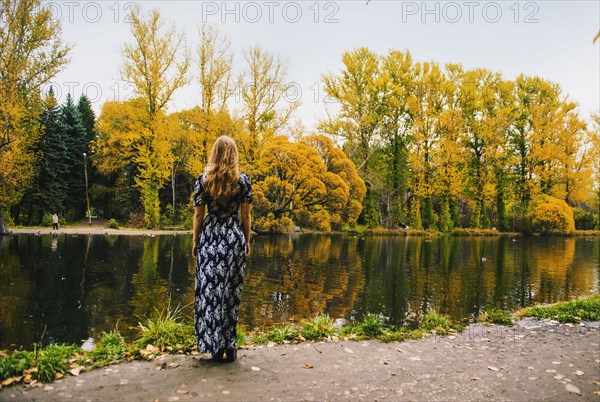 Caucasian woman admiring pond in park