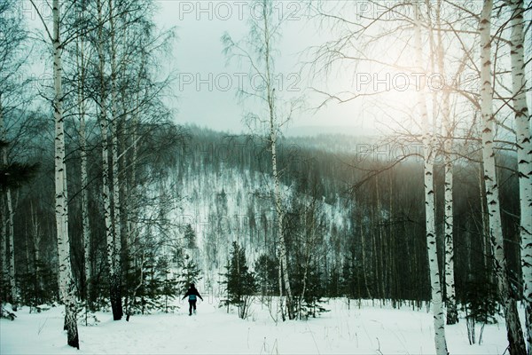 Hiker walking in snowy forest