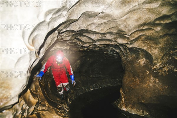 Caucasian hiker wearing headlamp in cave