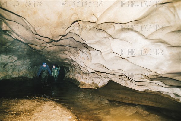 Caucasian hikers exploring cave