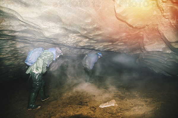 Caucasian hikers exploring cave