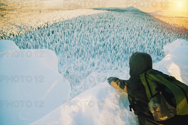 Hiker admiring view from snowy hilltop