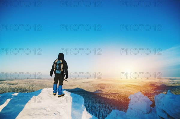 Hiker admiring view from snowy hilltop