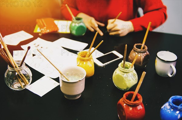 High angle view of artist and paint pots