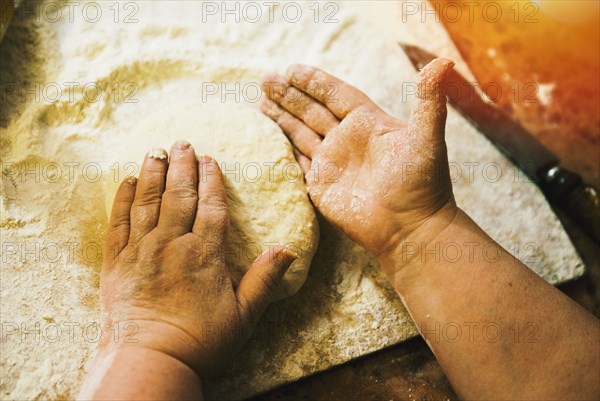 Close up of woman kneading loaf of bread