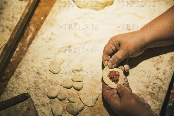 Close up of woman forming meat dumplings