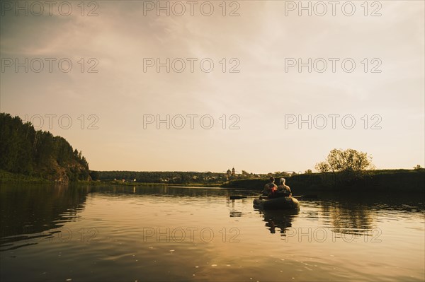 Caucasian family paddling boat on river
