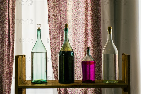 Bottles on shelf near window