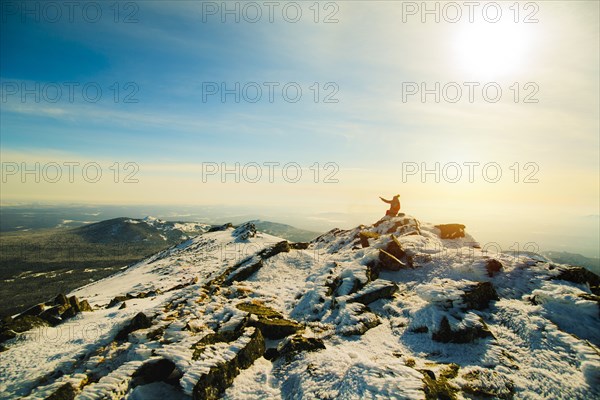 Woman sitting on mountain in winter