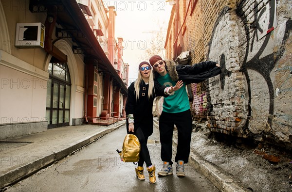 Couple gesturing stop in urban alley