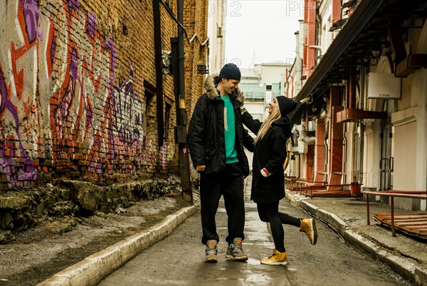 Playful couple in urban alley