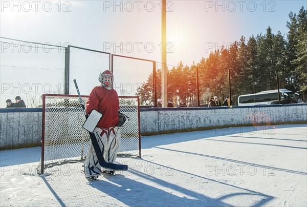 Caucasian boy playing goalie in ice hockey outdoors