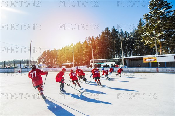 Caucasian boys playing ice hockey outdoors